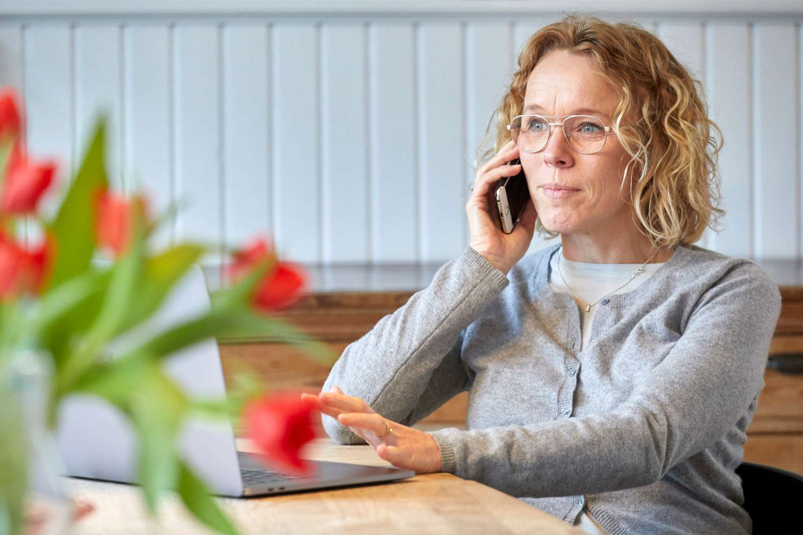 Dame foran computer taler i telefon Undgå fupopkald og svindel via telefonopkald